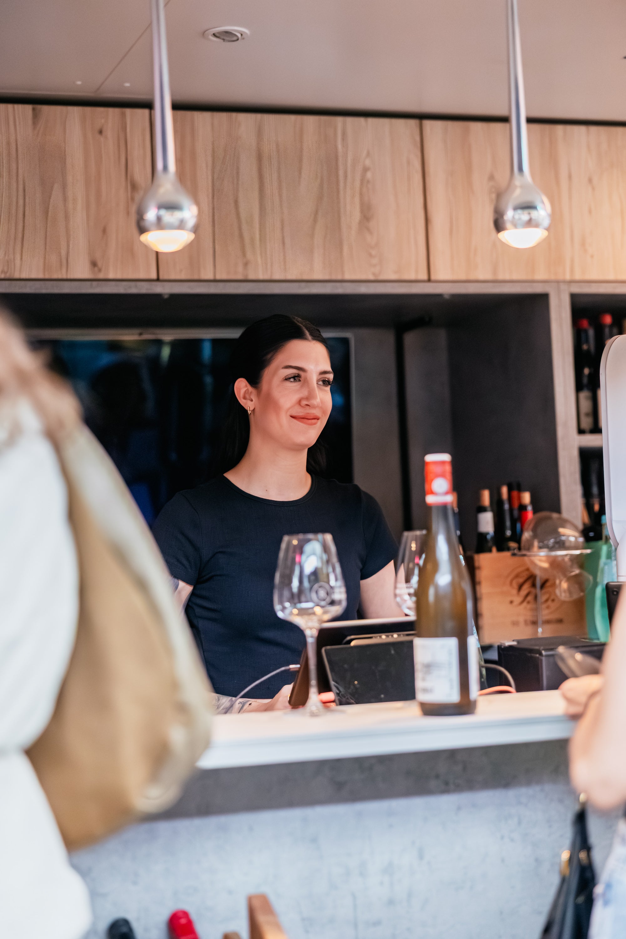 Mitarbeiterin am Tresen der Weinbar